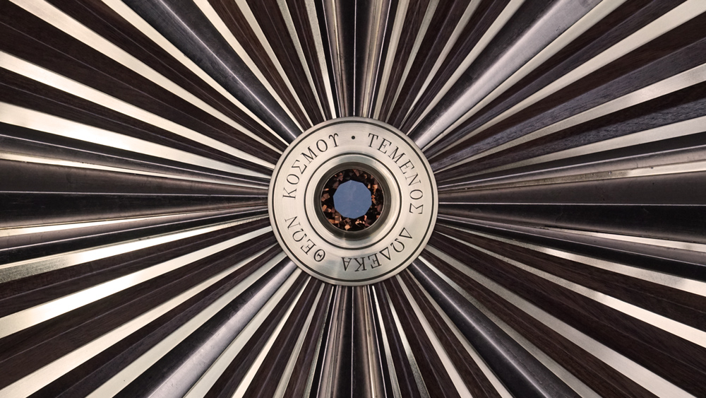 Large wooden wall sculpture made from walnut, brass and gold leaf, featuring three slow-rotating circular wheels set within a geometric framework. Handcrafted with fine cabinetmaking techniques, the piece is motorized for silent, continuous movement.