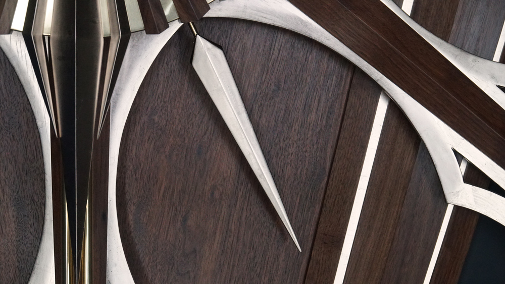 Large wooden wall sculpture made from walnut, brass and gold leaf, featuring three slow-rotating circular wheels set within a geometric framework. Handcrafted with fine cabinetmaking techniques, the piece is motorized for silent, continuous movement.