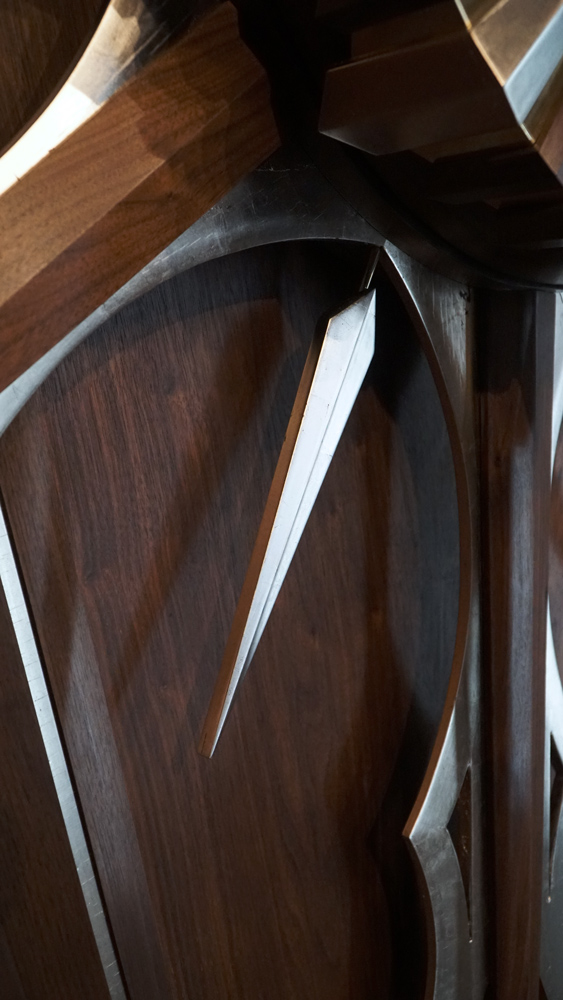 Large wooden wall sculpture made from walnut, brass and gold leaf, featuring three slow-rotating circular wheels set within a geometric framework. Handcrafted with fine cabinetmaking techniques, the piece is motorized for silent, continuous movement.